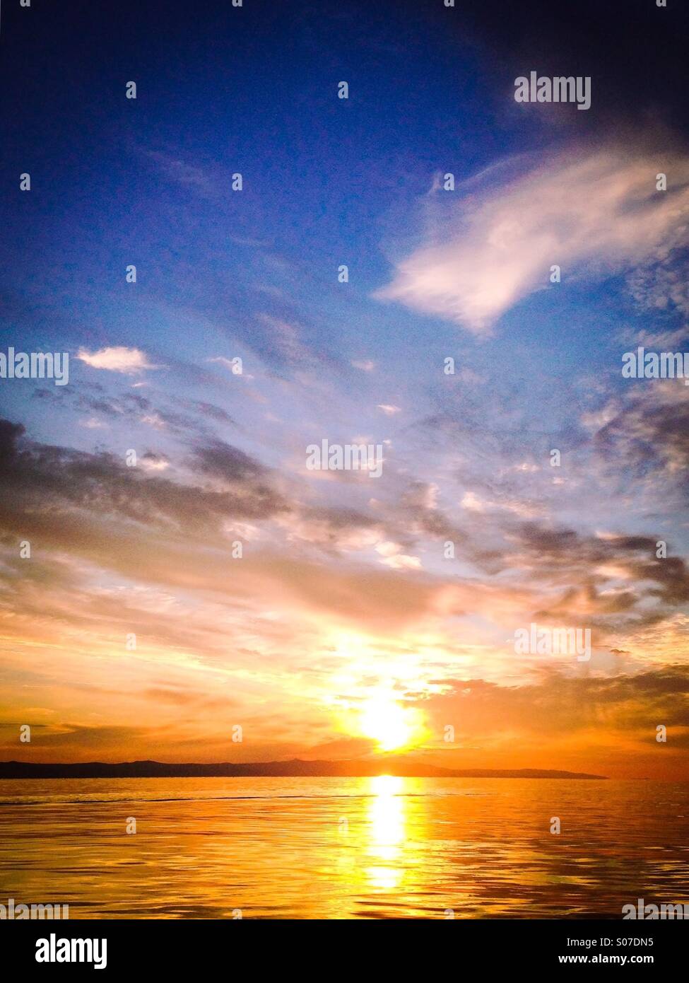 Scena al tramonto con mare calmo e cielo colorato Foto Stock