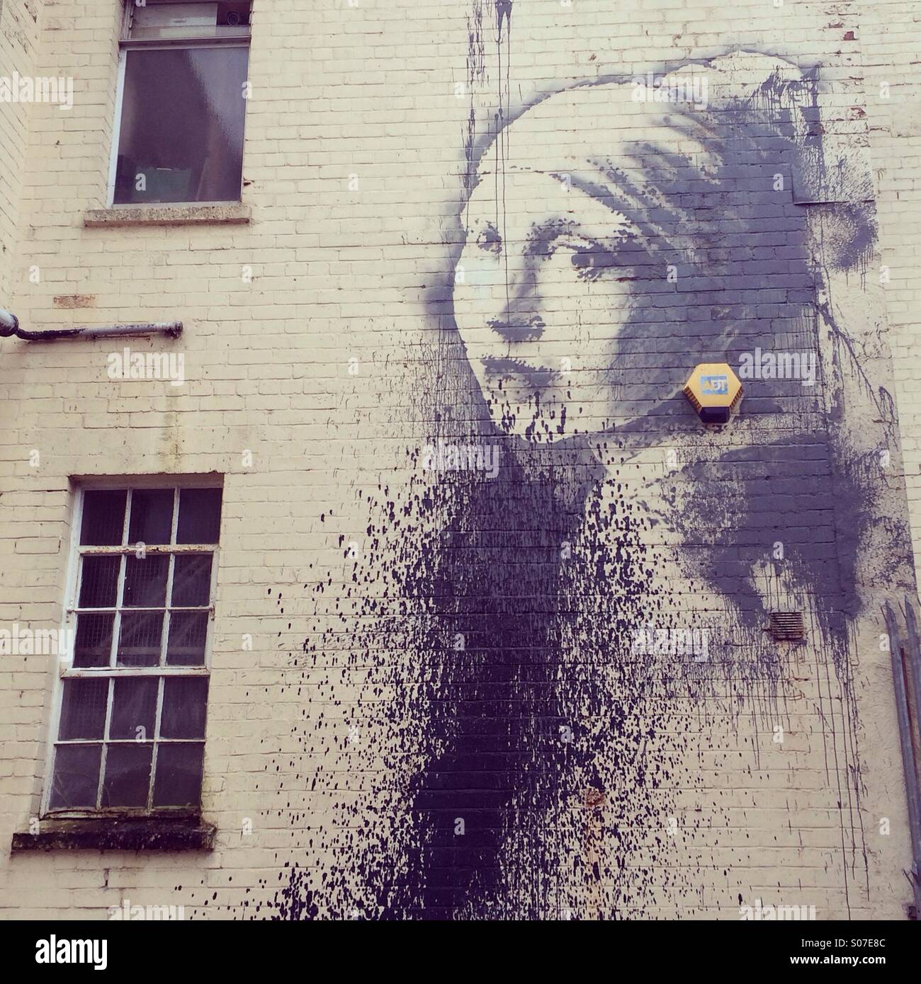 Banksy della ragazza con un timpano forato Foto Stock