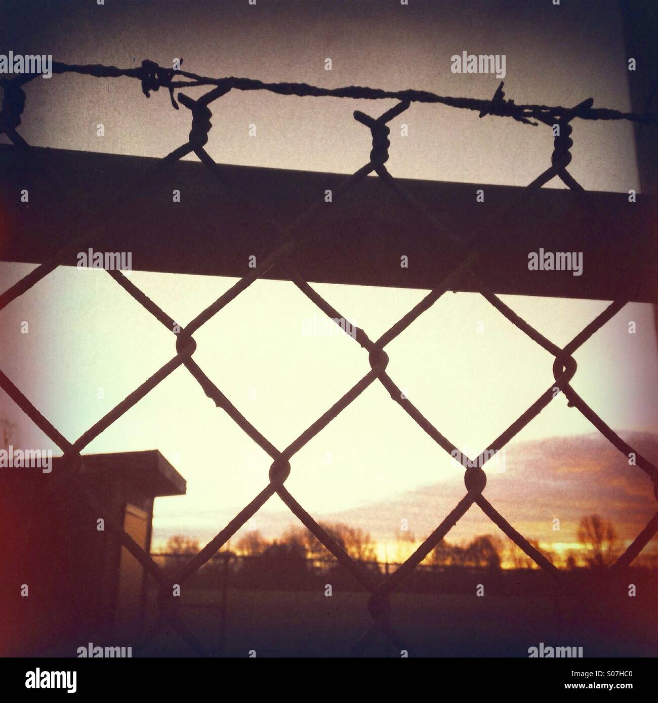 Silhouette di catena collegamento recinto e filo portagomma - Immagine stock catturata con smartphone