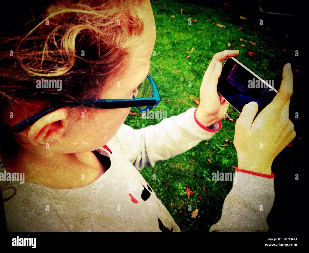 Ragazza giovane la riproduzione su iPhone Foto Stock