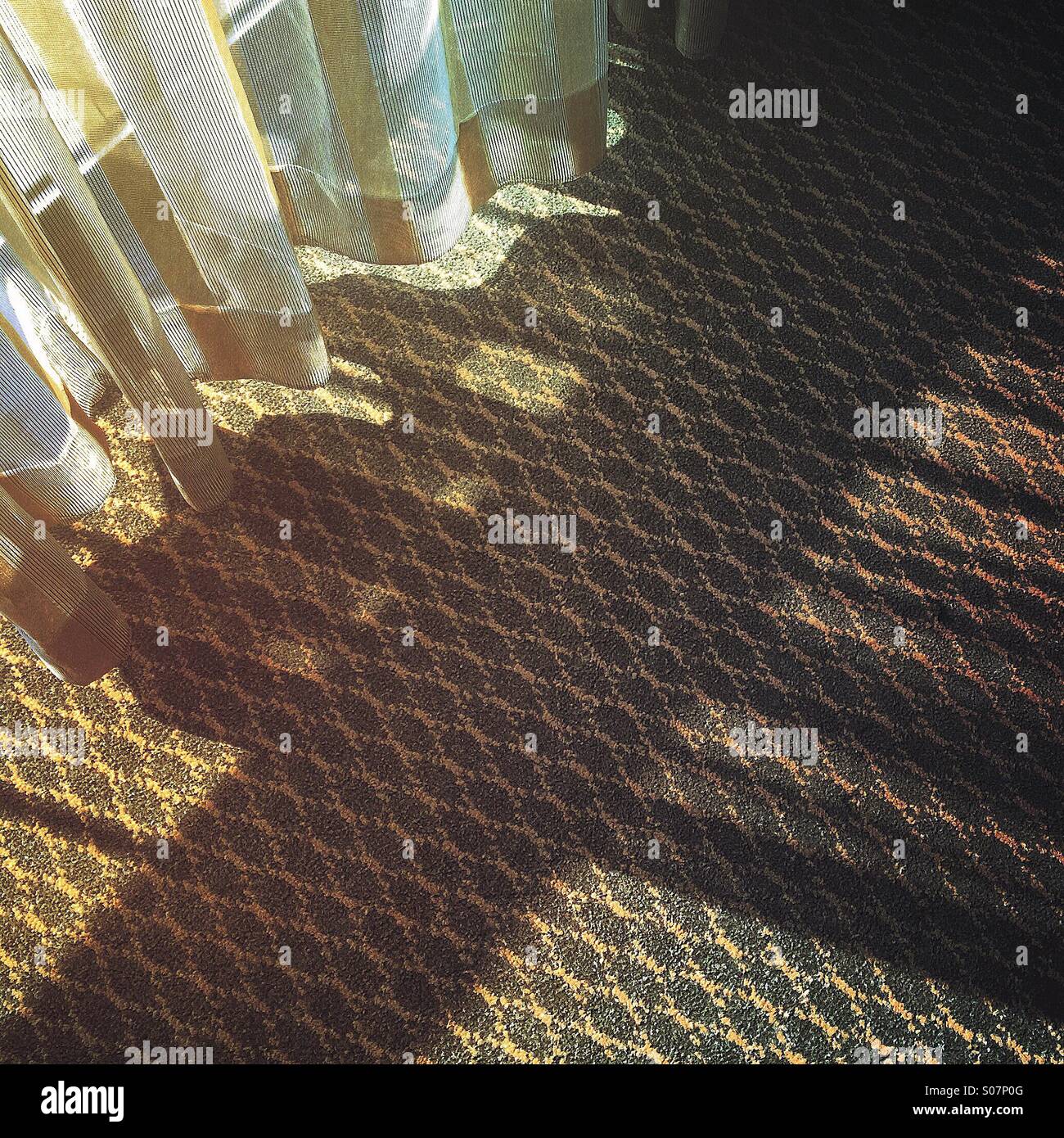 La luce del sole attraverso Cortina traslucida e shadow pattern sul tappeto. Foto Stock
