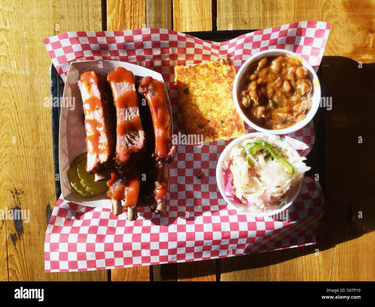 Barbecue meridionale di nervature con fagioli al forno, coleslaw e cornbread, a Moe's BBQ originale in Panama City Beach, Florida, Stati Uniti d'America. - Immagine stock catturata con smartphone