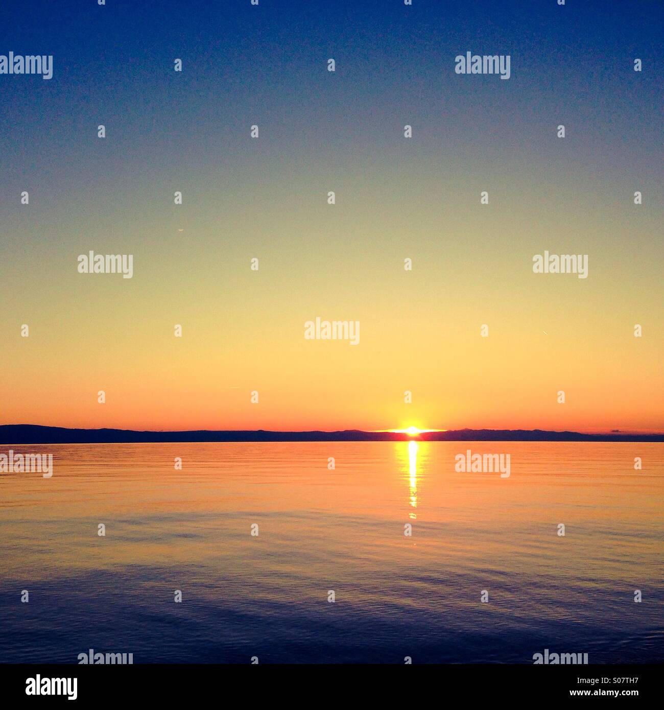 Bel tramonto al mare calmo Foto Stock