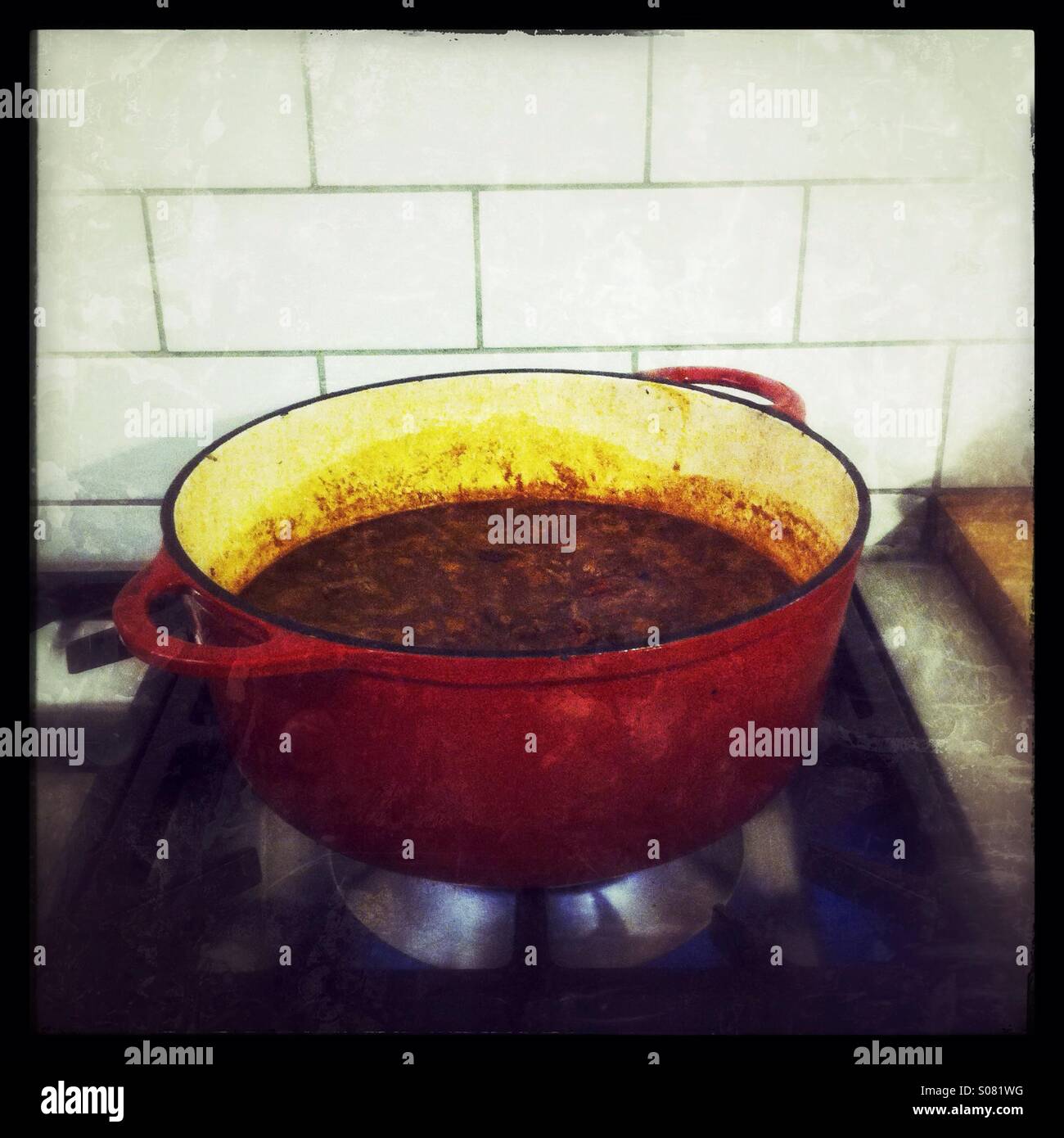 Cottura del peperoncino in una grande pentola in ghisa - Immagine stock catturata con smartphone