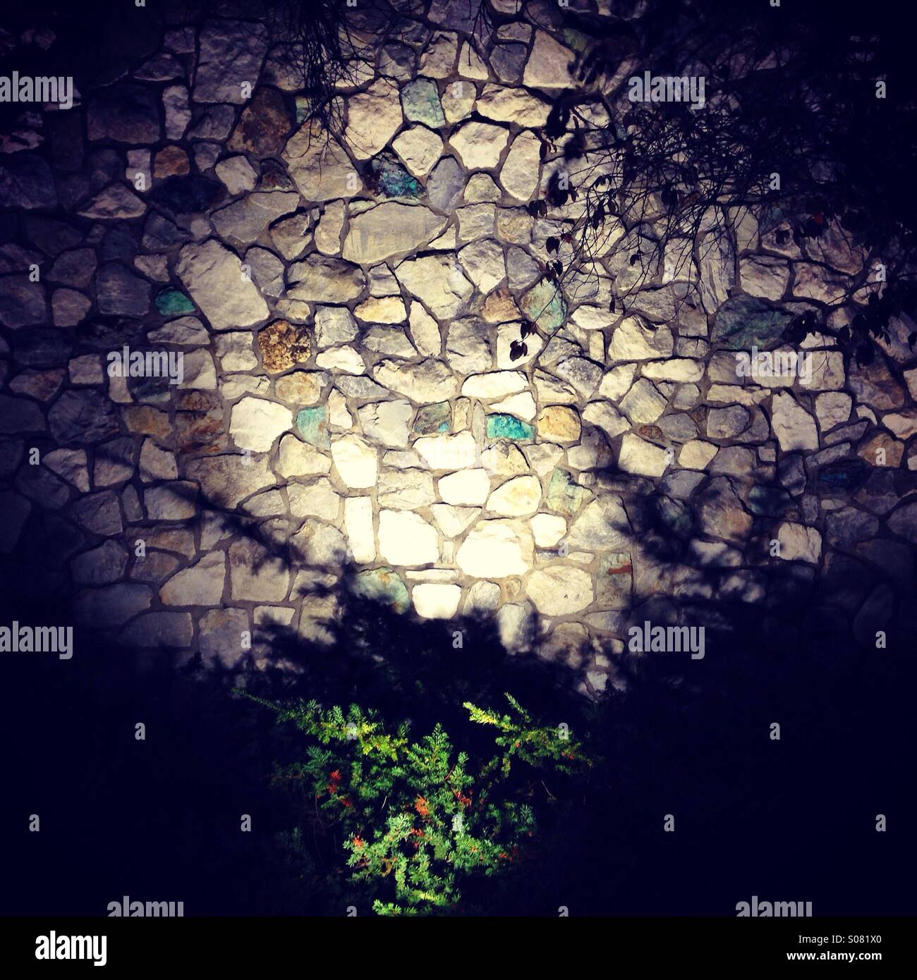 Muro di pietra con alluvione luce di notte Foto Stock