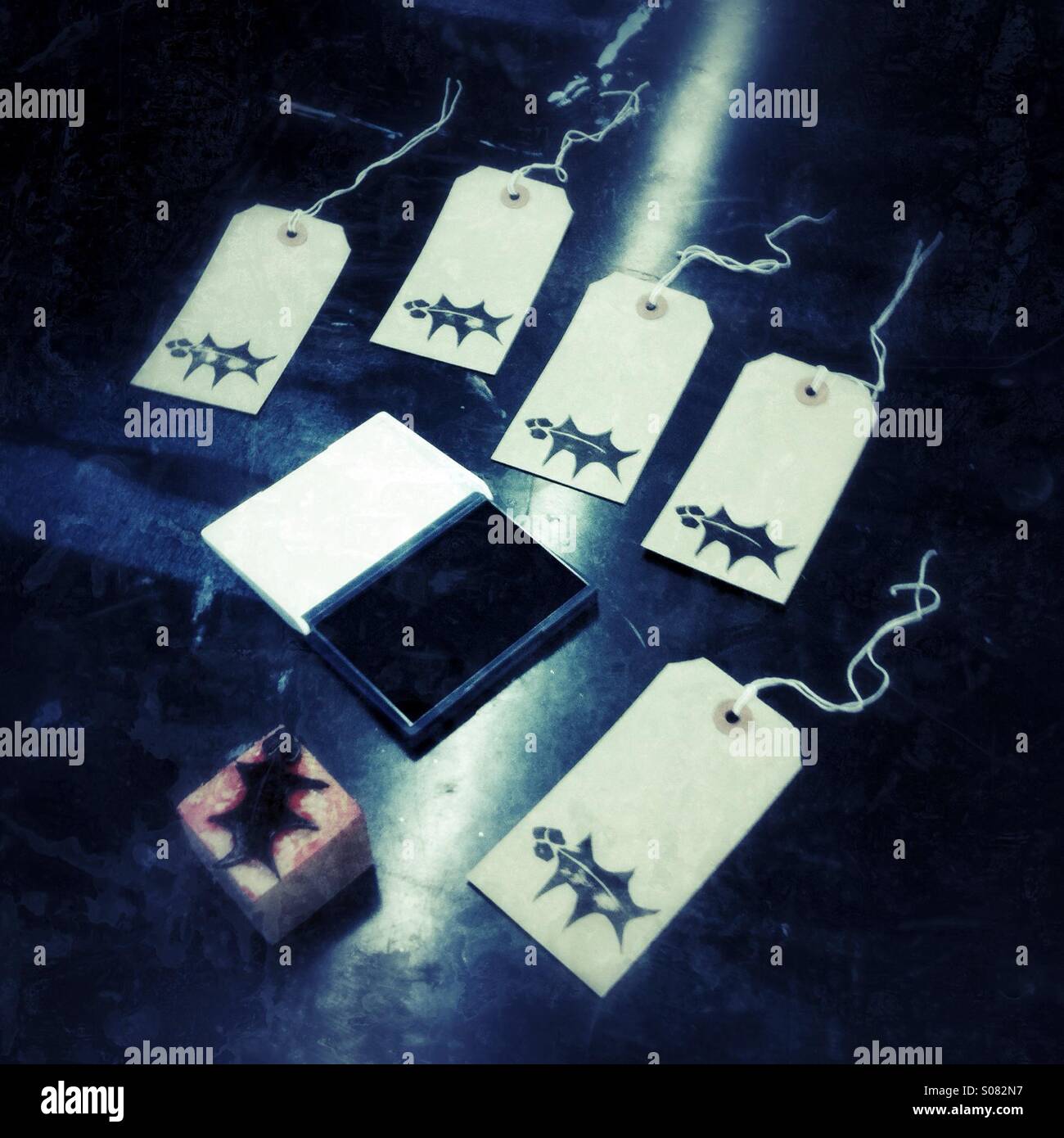 In casa natale tags stampato con una foglia di agrifoglio e bacche Foto Stock