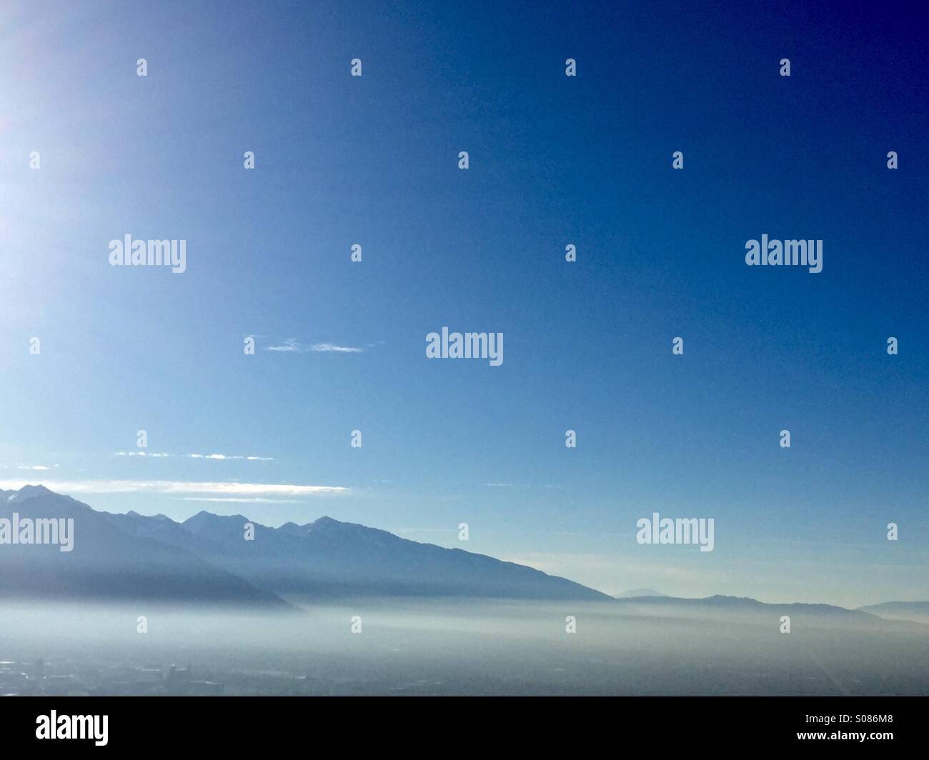 Uno strato di inversione coperte la Salt Lake Valley con Wasatch Mountains nella distanza. Foto Stock