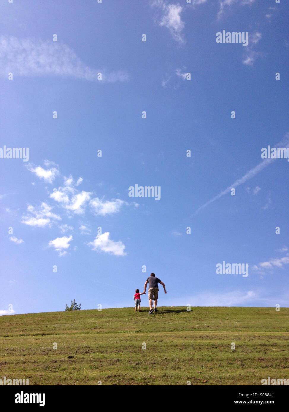 Padre e Figlio a piedi up steep hill Foto Stock