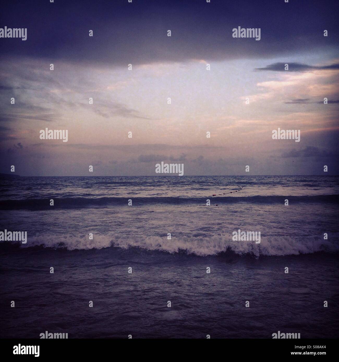 Mare ondeggiante al tramonto Foto Stock
