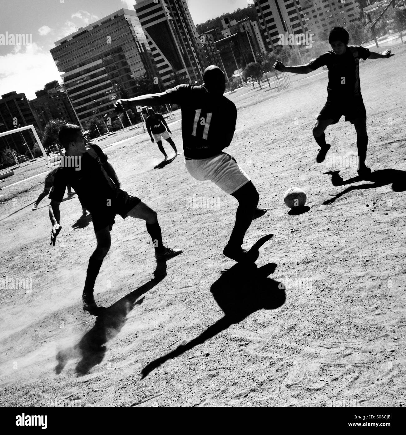 Uomini ecuadoriana giocare a calcio su una sporcizia di calcio nel Parque La Carolina, un parco nel quartiere centrale degli affari di Quito, Ecuador, 1 ottobre 2014. Foto Stock