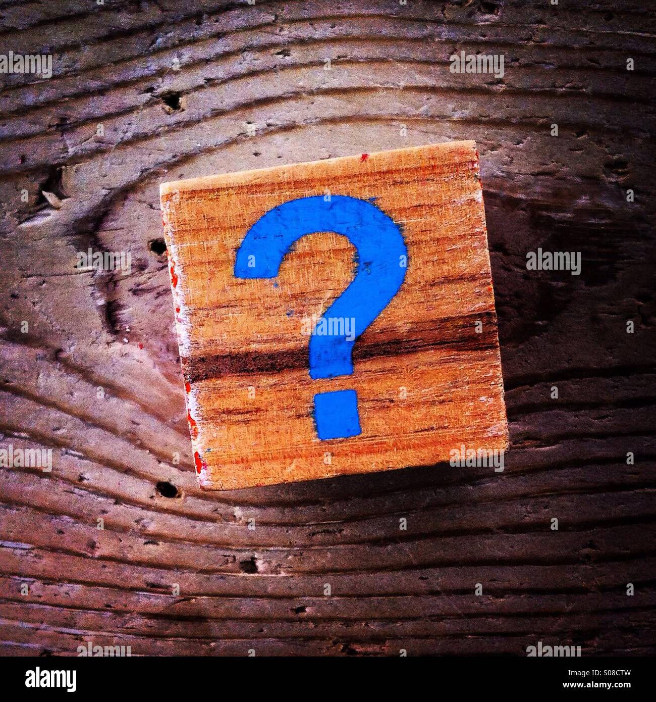 Punto interrogativo di colore blu su un cubo di legno - Immagine stock catturata con smartphone