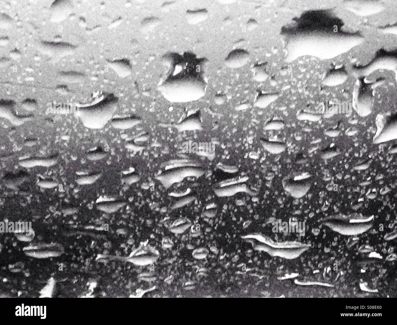Gocce di pioggia sul vetro del finestrino Foto Stock