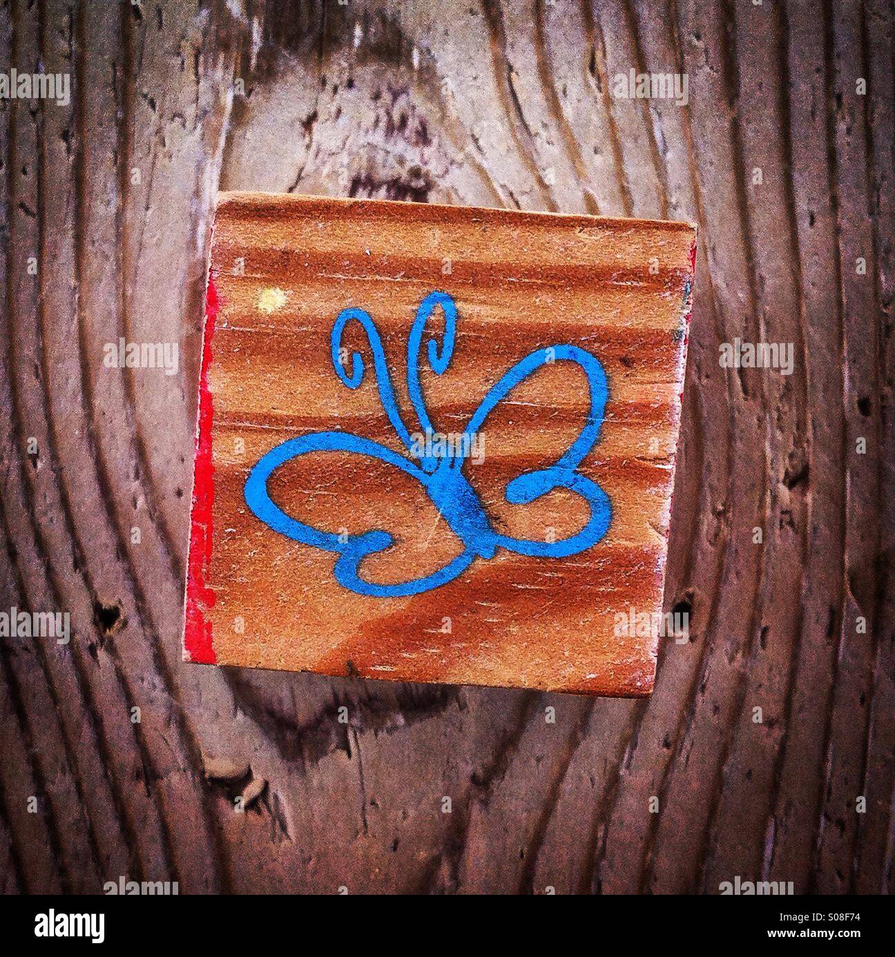 Blue Butterfly su un blocco di legno - Immagine stock catturata con smartphone