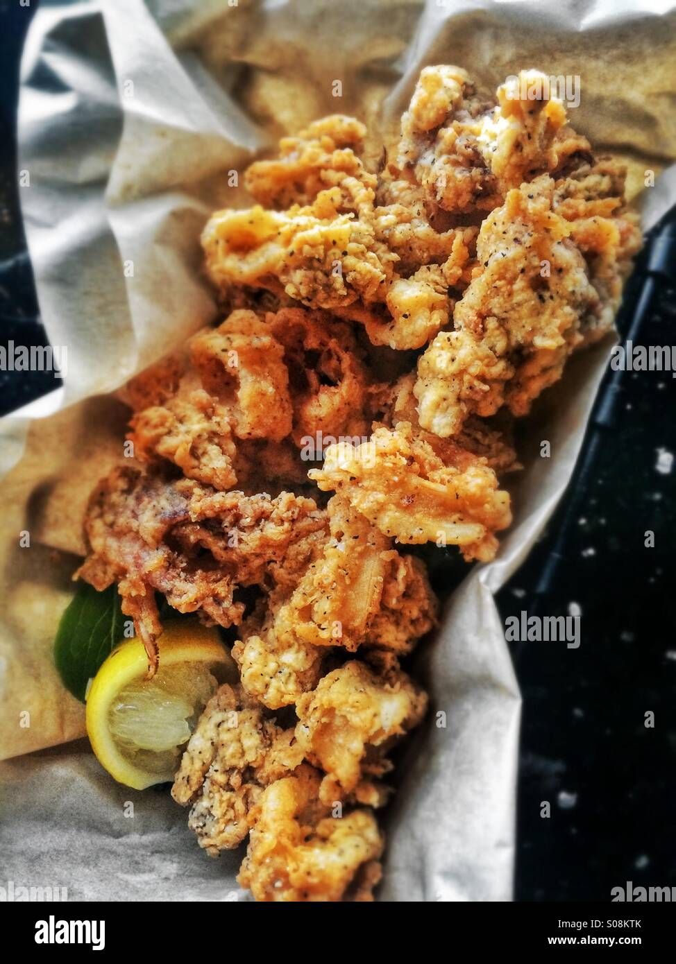 Profonda calamari fritti pastella rivestita con il sale e la fetta di limone Foto Stock