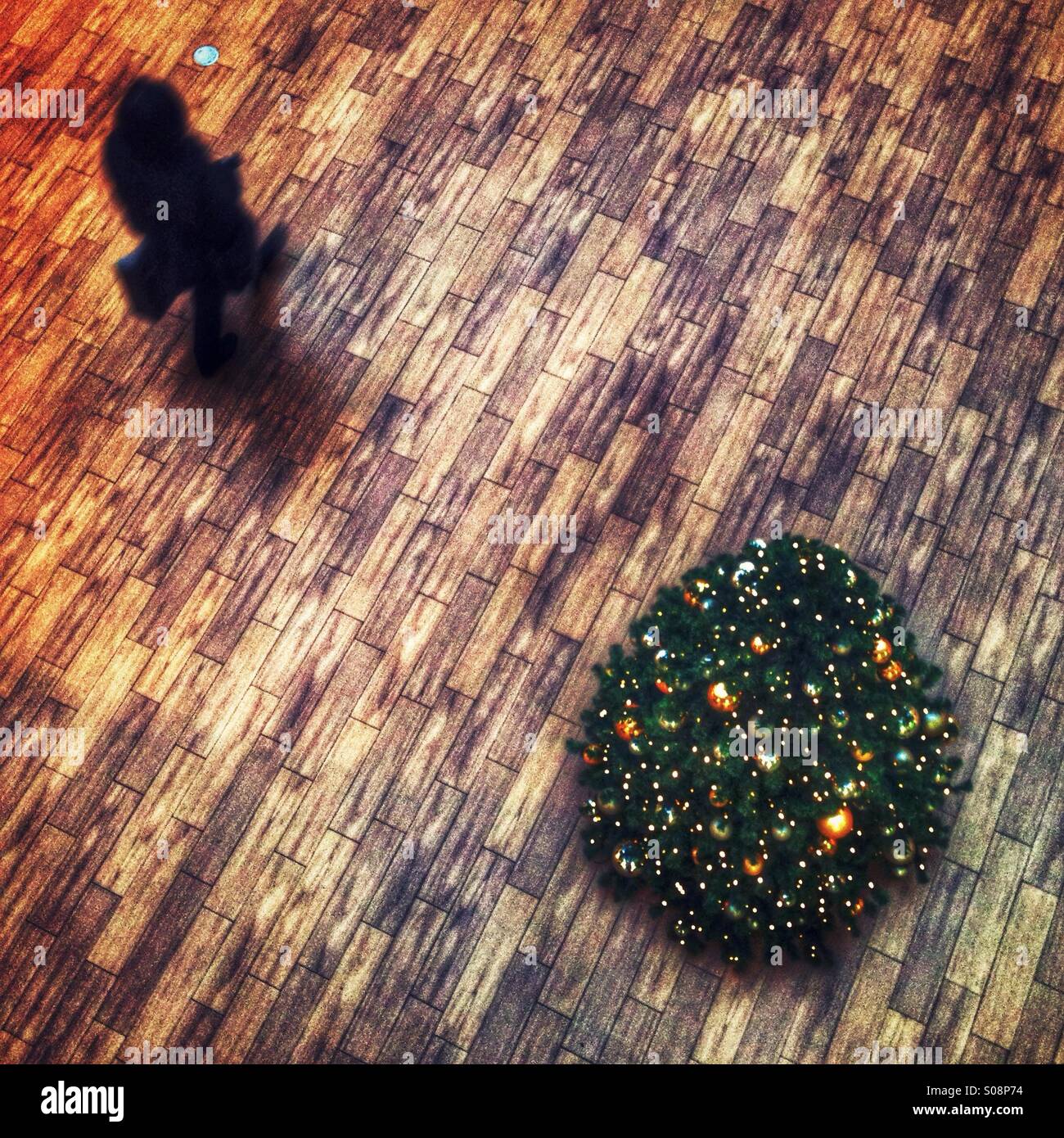 Tettuccio di colpo di shopper a piedi da un albero di Natale Foto Stock