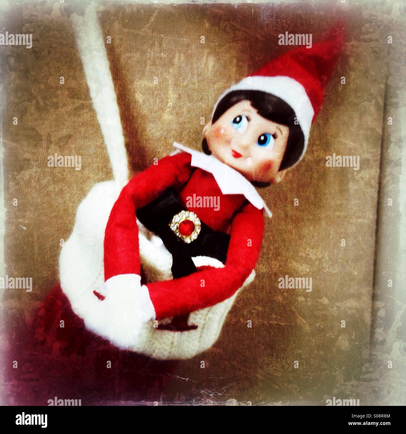 Un elfo in giro in una calza di Natale. Foto Stock