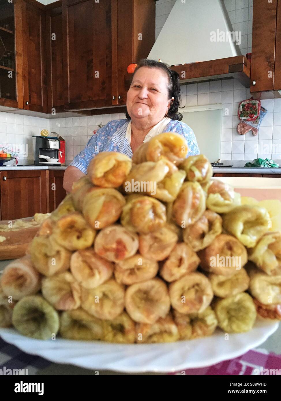 La nonna in cucina con il tradizionale piatto rumeno, sarmale, foglie di  cavolo ripiene di carne tritata Foto stock - Alamy
