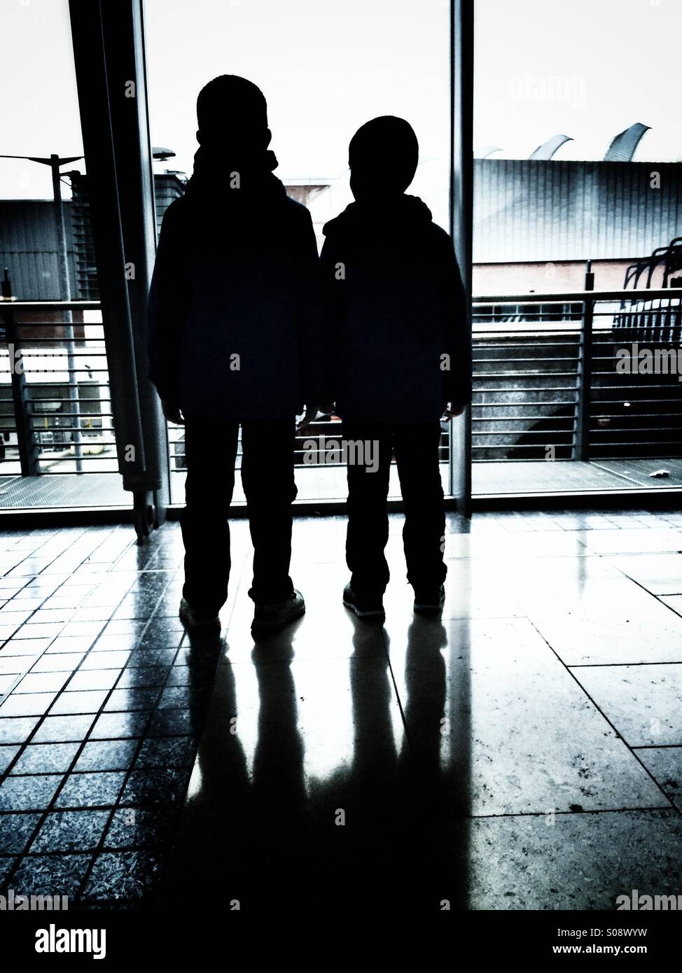 Due ragazzi in piedi all'interno di un edificio Foto Stock