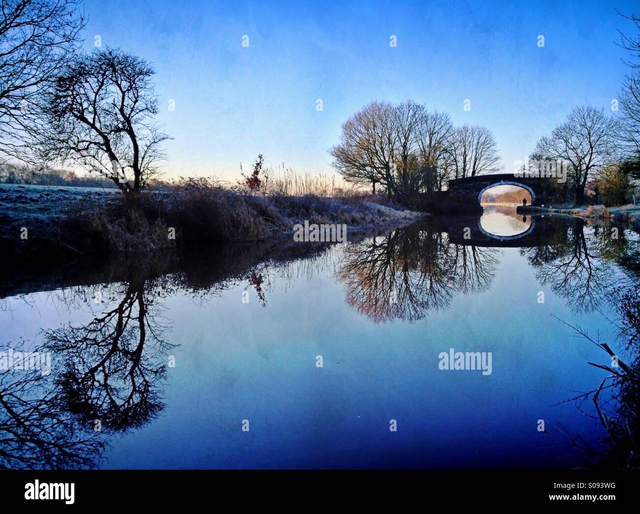 Immagine speculare riflessione di alberi e ponte in Leeds Liverpool canal vicino a Chorley in Lancashire Foto Stock
