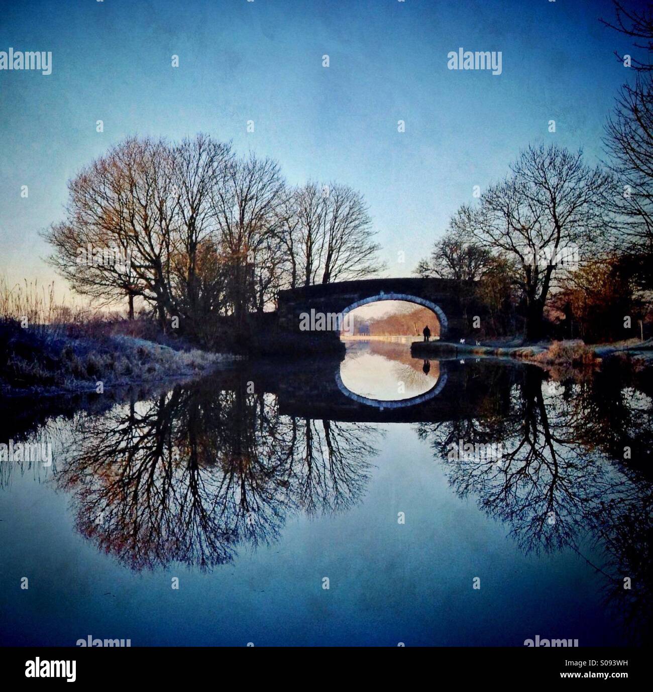 Immagine a specchio di riflessione del ponte e alberi in Leeds Liverpool canal vicino a Chorley Foto Stock