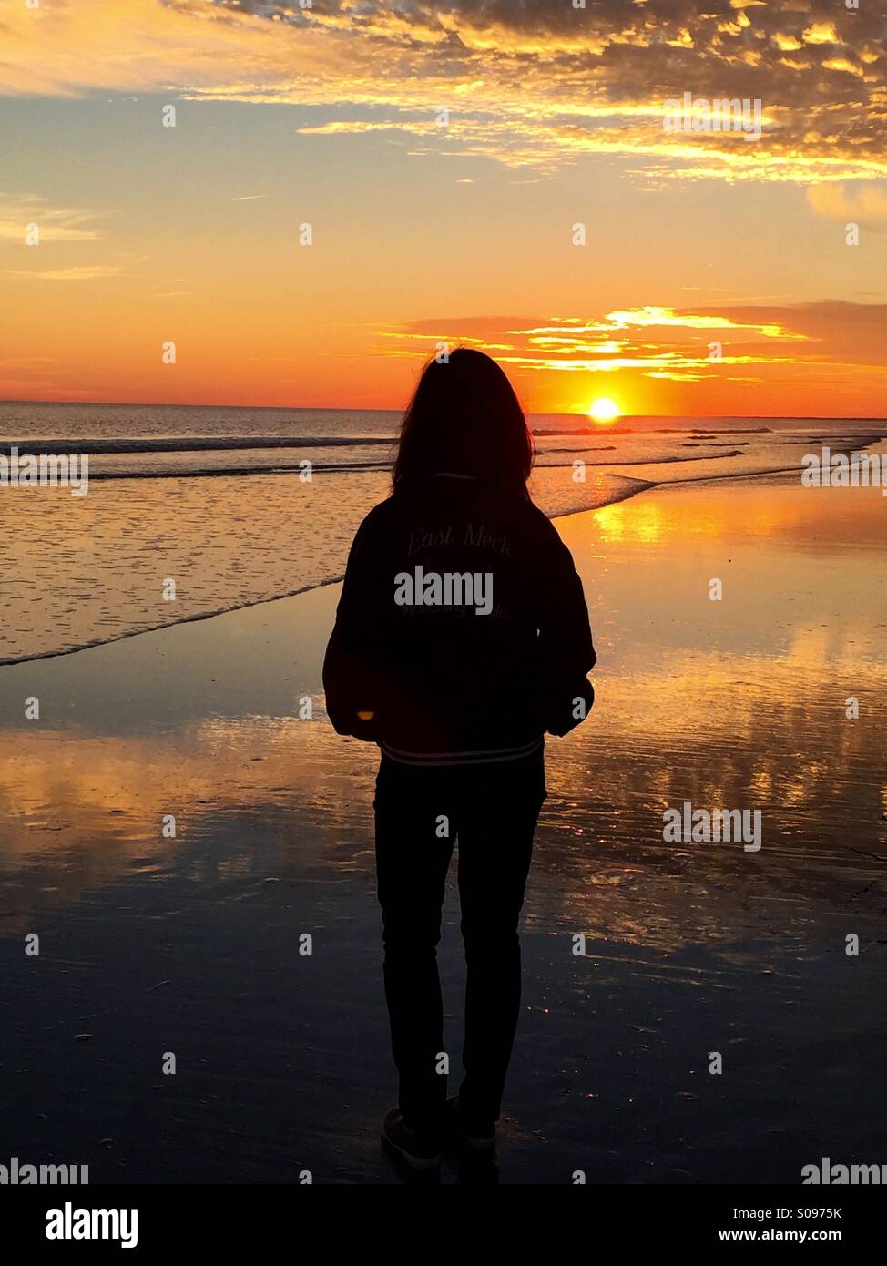 E la donna si stagliano contro la intensa, bel tramonto sulla spiaggia il Kiawah Island, nella Carolina del Sud. Foto Stock