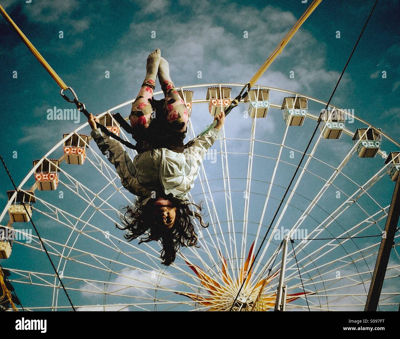 Ragazza giovane acrobat su un cavo elastico in un parco di divertimenti Foto Stock