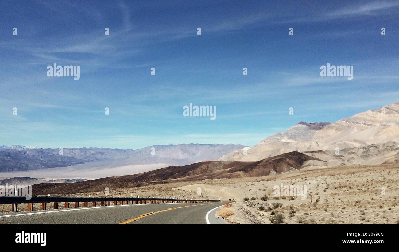 Una strada vuota nel west americano con una vista in lontananza le colline Foto Stock