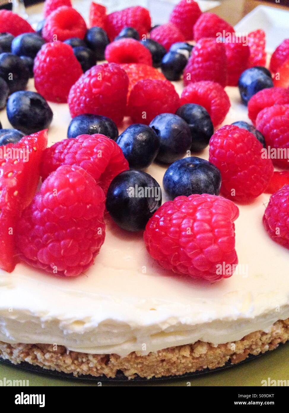 Torta di formaggio con lamponi e mirtilli - Immagine stock catturata con smartphone