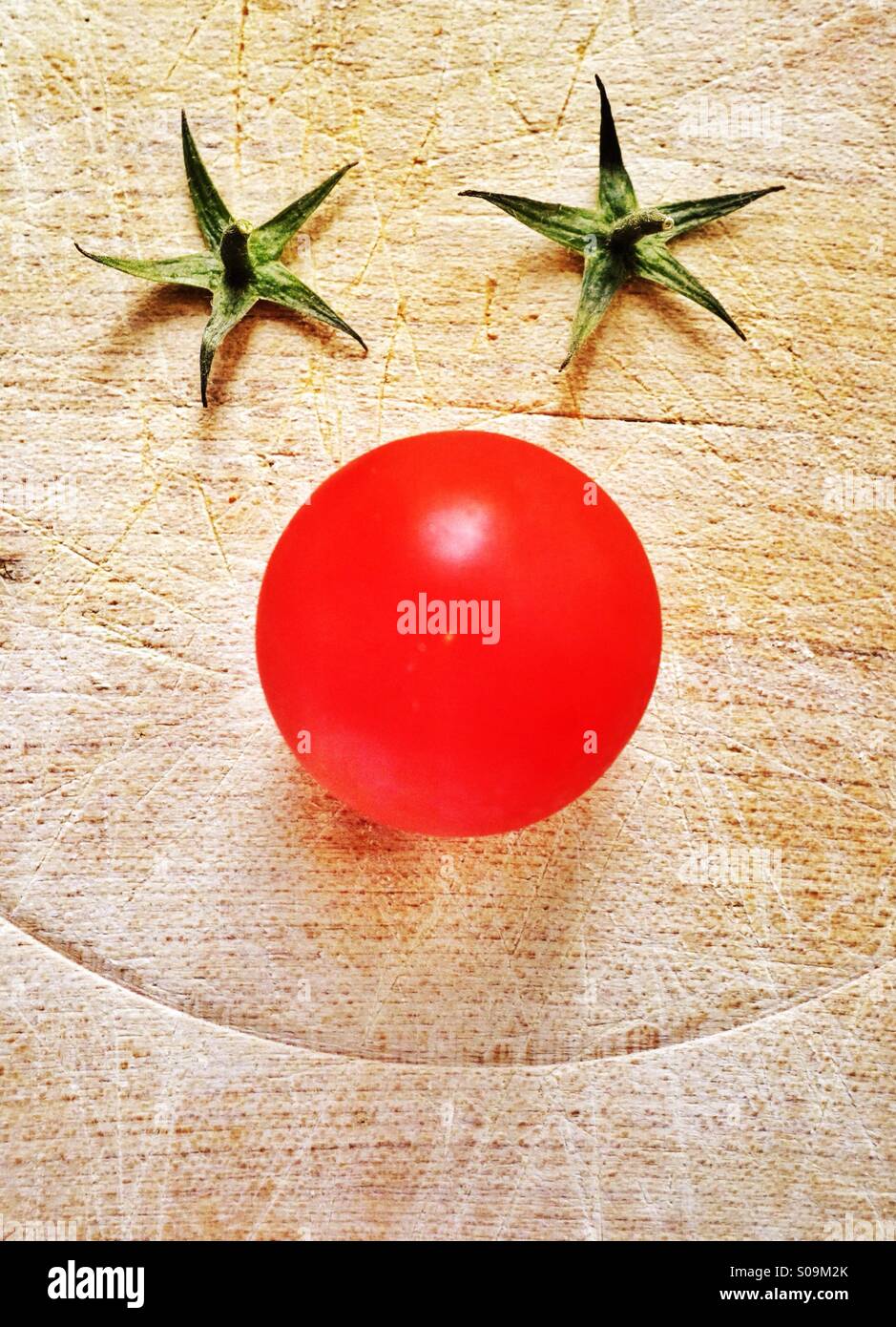Clowning Around - un clown volto appare sul tagliere con un pomodoro per un naso e rimosso i culmi come occhi Foto Stock