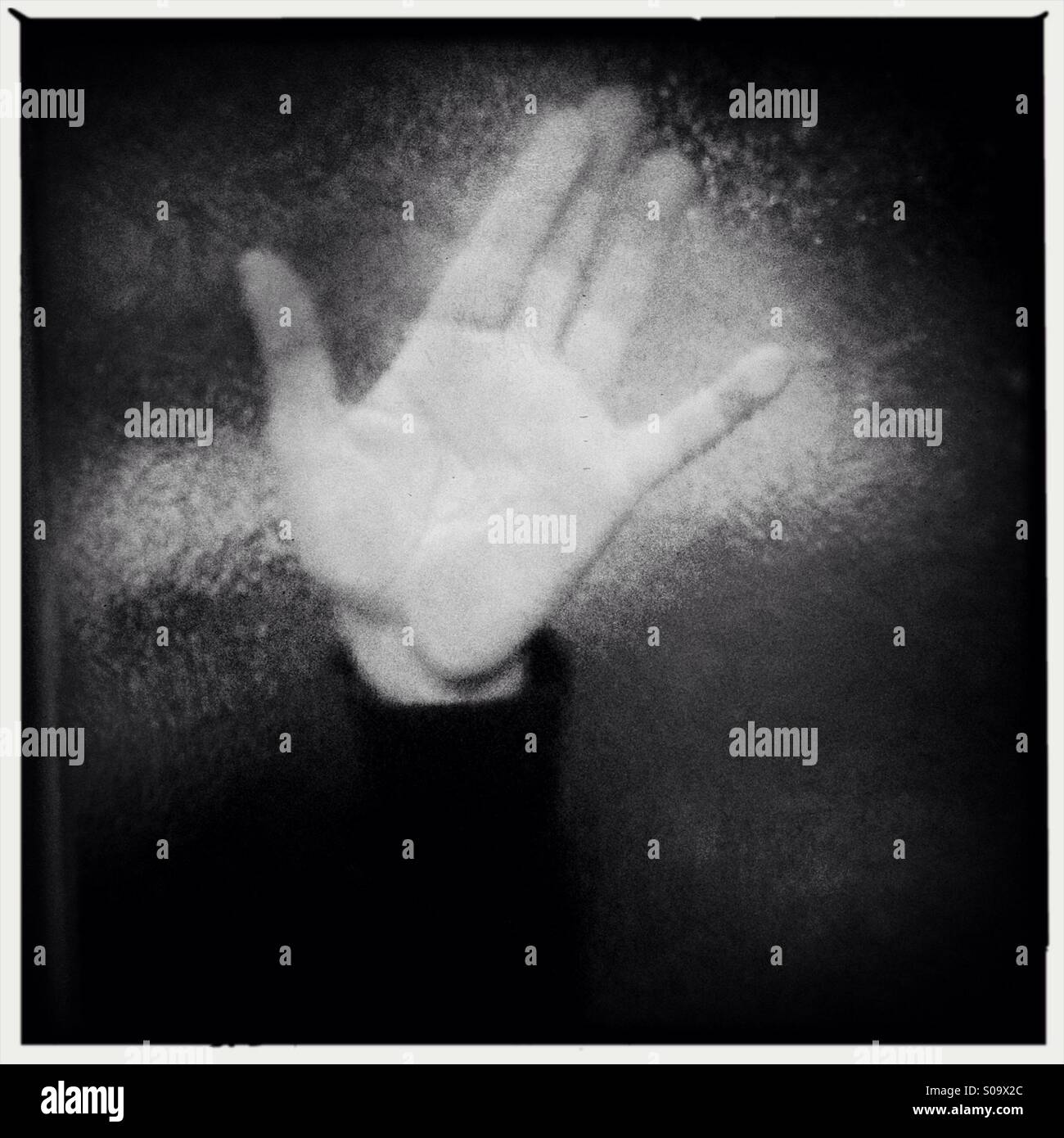 La mano di una persona contro il vetro macchiato - Immagine stock catturata con smartphone