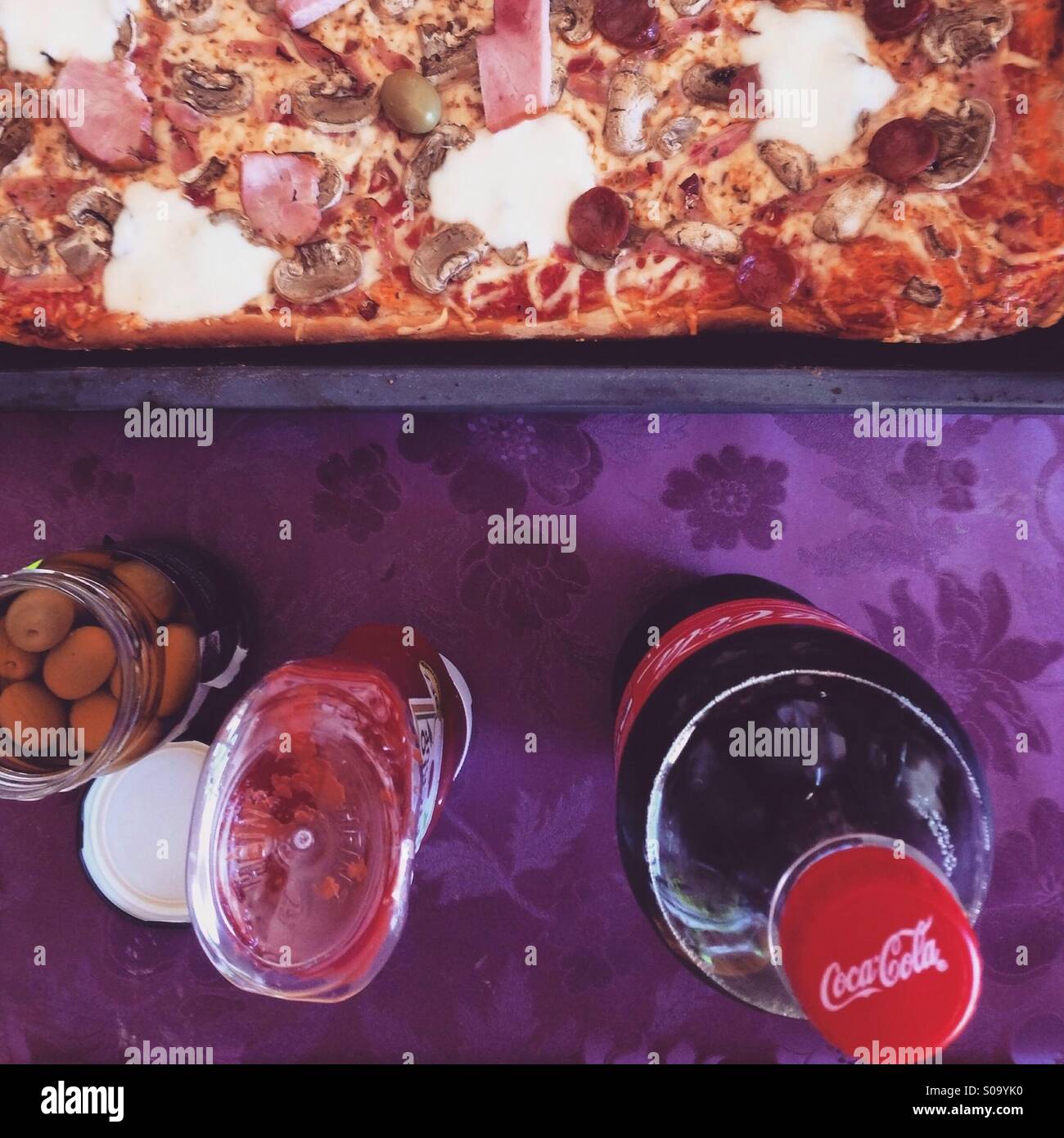Pizza e coca cola sul tavolo, sparare da sopra Foto Stock