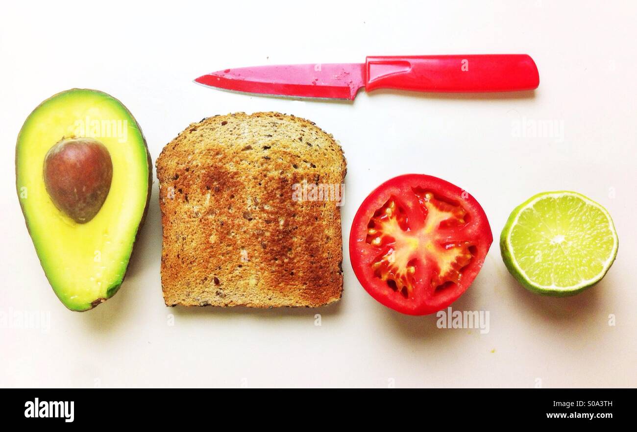 Realizzazione di una Vegana Vegetariana/sandwich aperto con avocado, pomodoro e pane integrale tostato. - Immagine stock catturata con smartphone