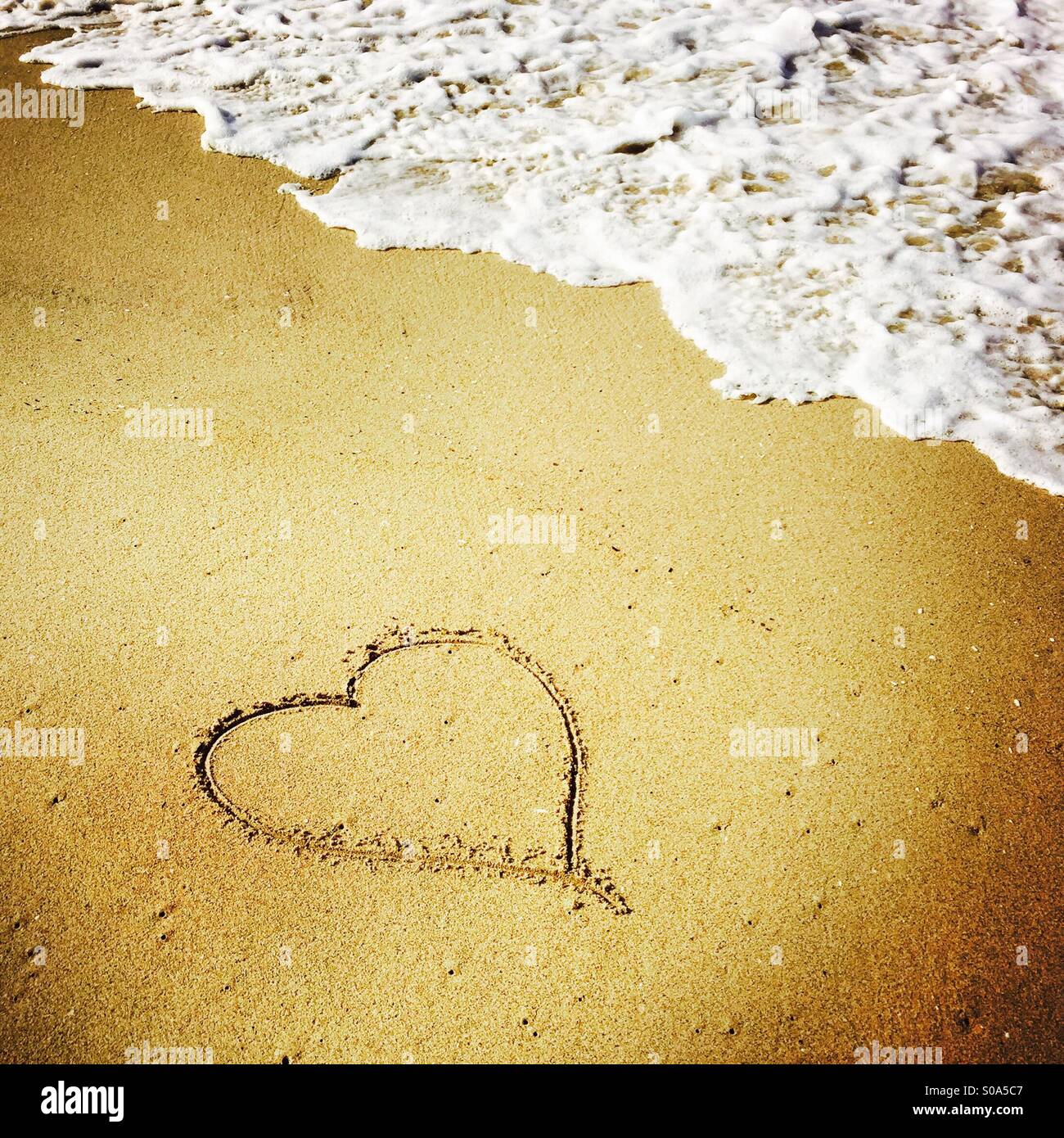 Un cuore disegnato nella sabbia al litorale. Manhattan Beach, California USA. Foto Stock