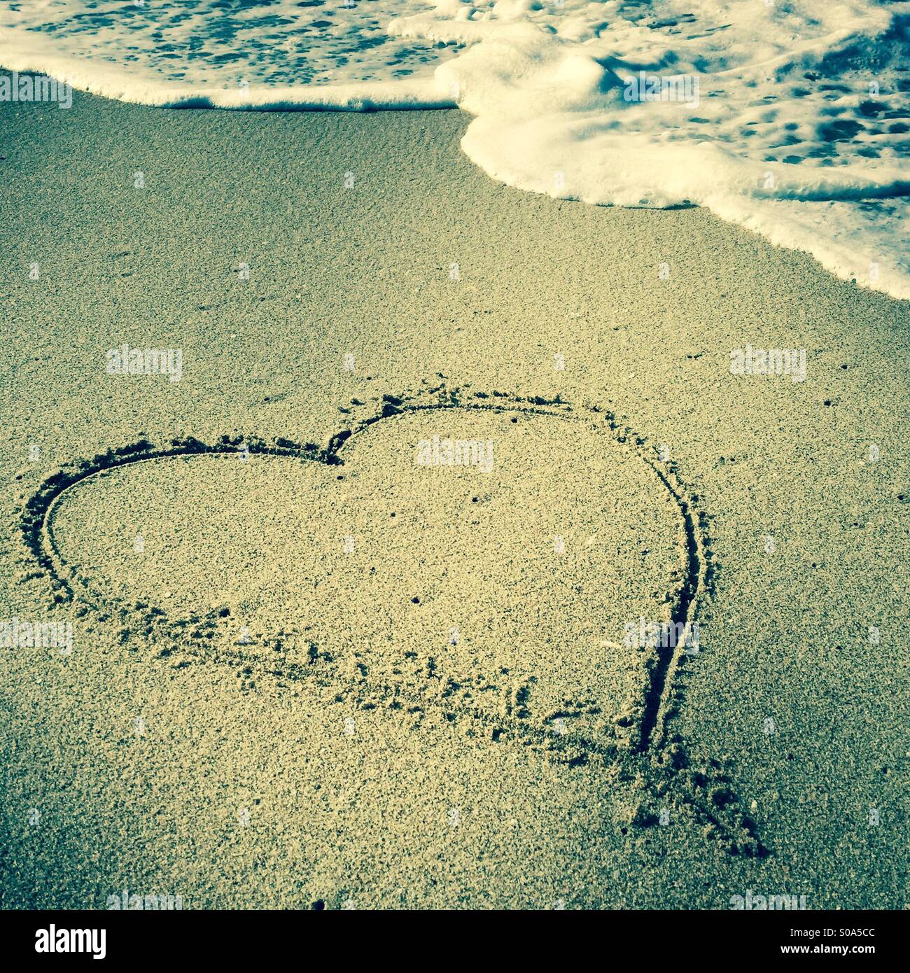 Un cuore disegnato nella sabbia al litorale. Manhattan Beach, California USA. Foto Stock