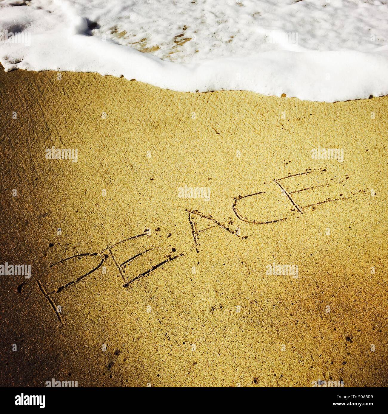 'Pace' scritto nella sabbia al litorale. Manhattan Beach, California USA. Foto Stock