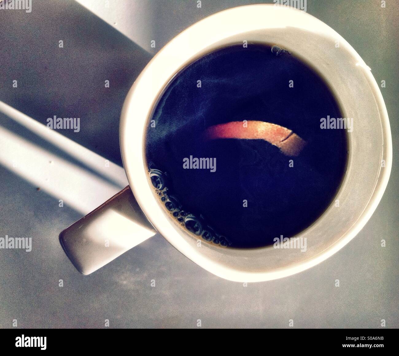 Nero caffè con limone giallo in bianco mug Foto Stock