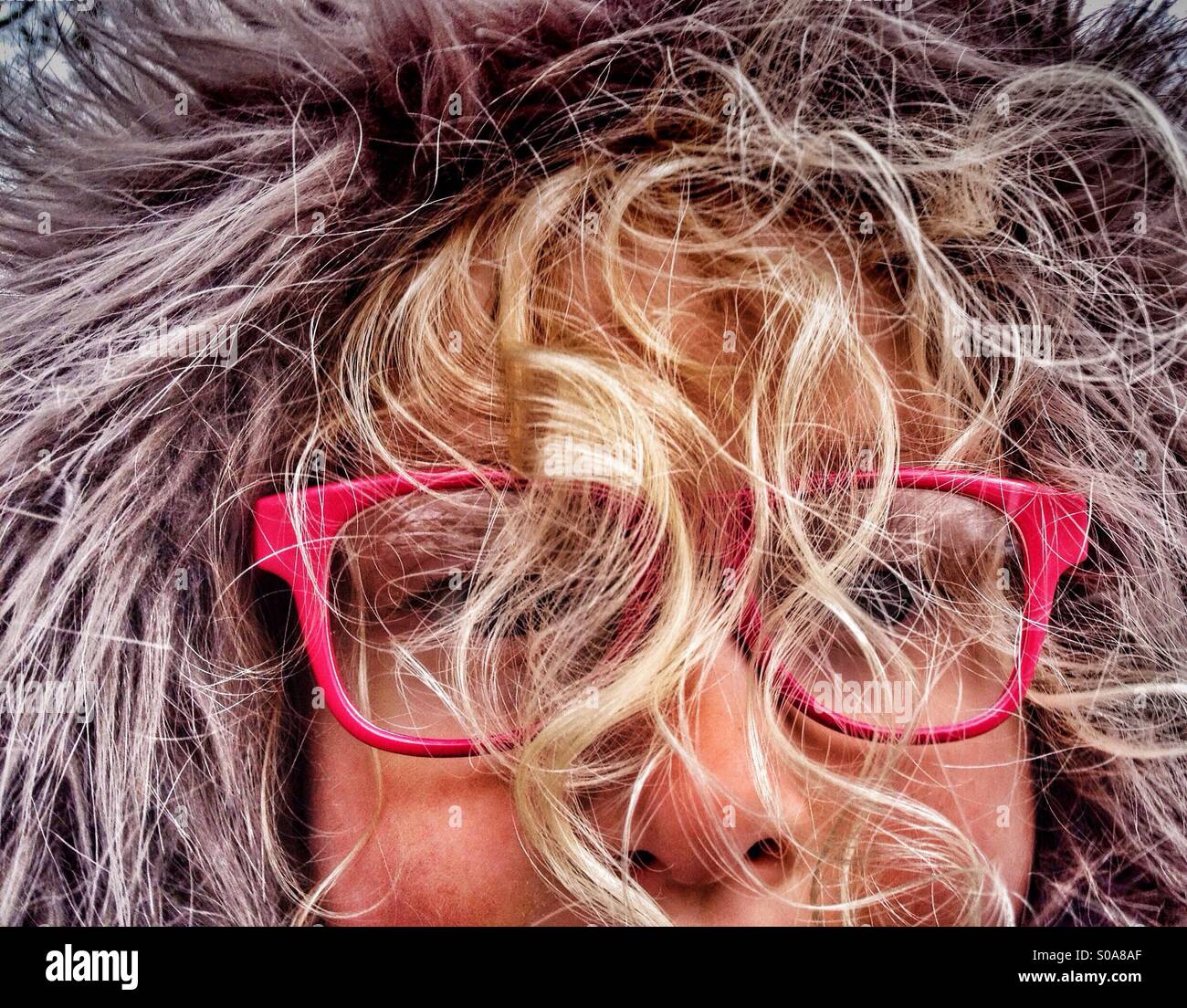 Giovane ragazza che indossa la cappa peloso con la faccia oscurata da ricci capelli cieco Foto Stock