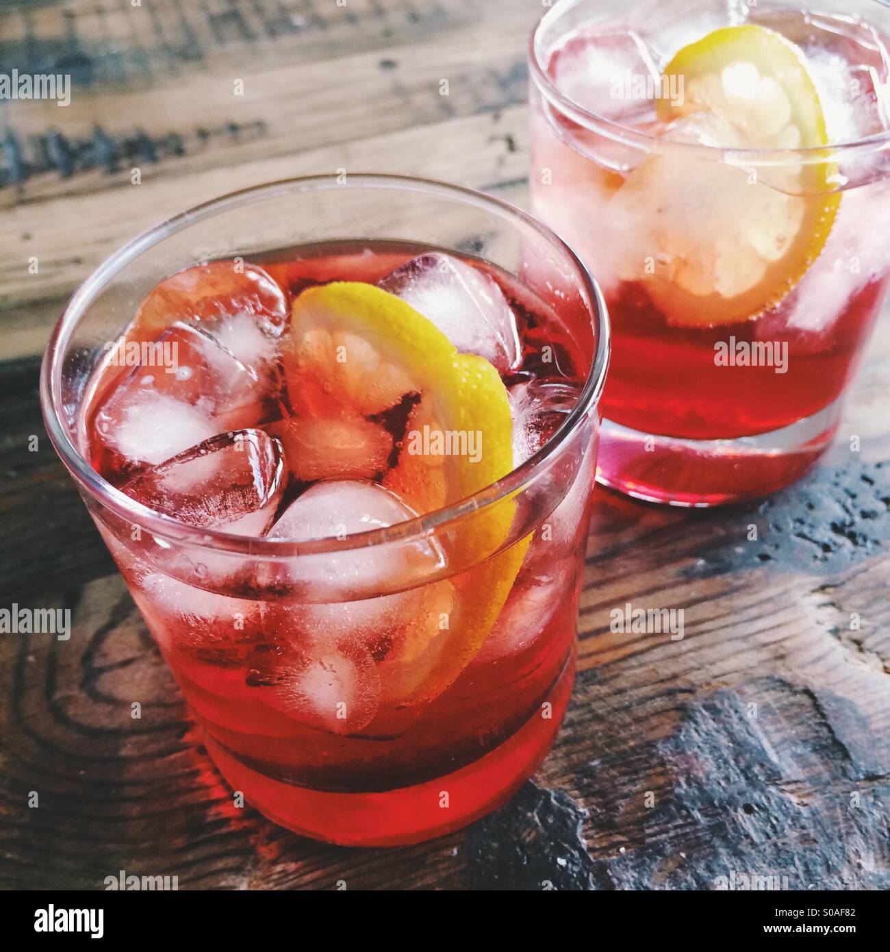 Due bicchieri di Campari Soda e limone su tavola in legno rustico Foto  stock - Alamy