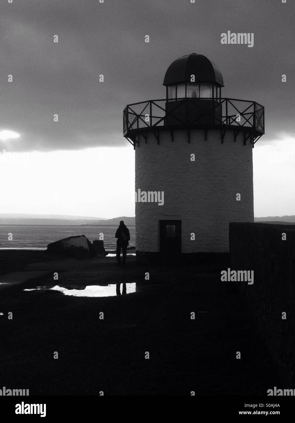 In bianco e nero della silhouette uomo accanto alla porta Burry faro Foto Stock