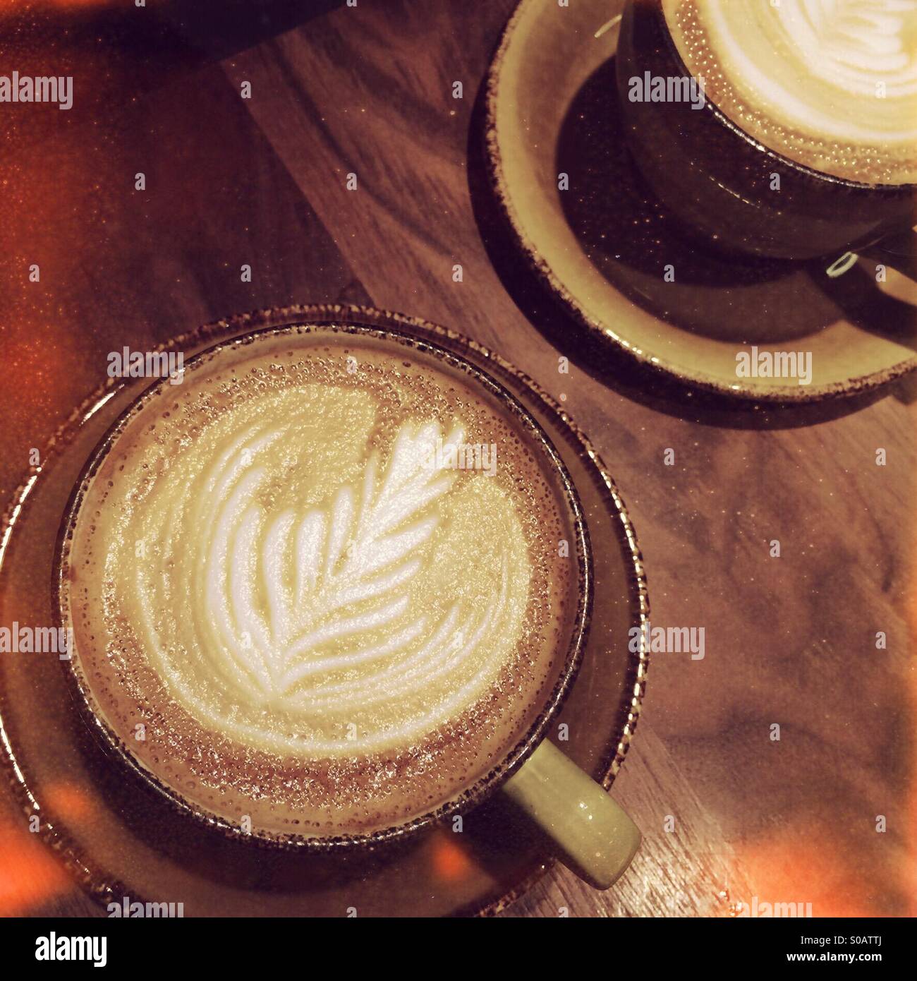 Due piatto bianco le bevande a base di caffè in una tabella in un cafe Foto Stock