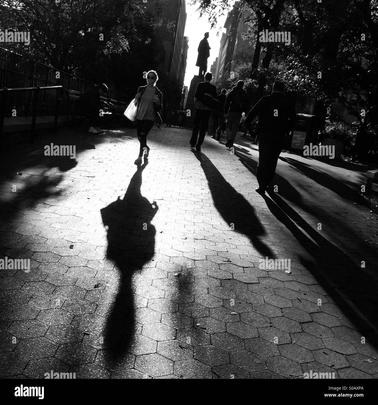 I popoli ombre come camminare attraverso la Union Square Park a Manhattan. Foto Stock