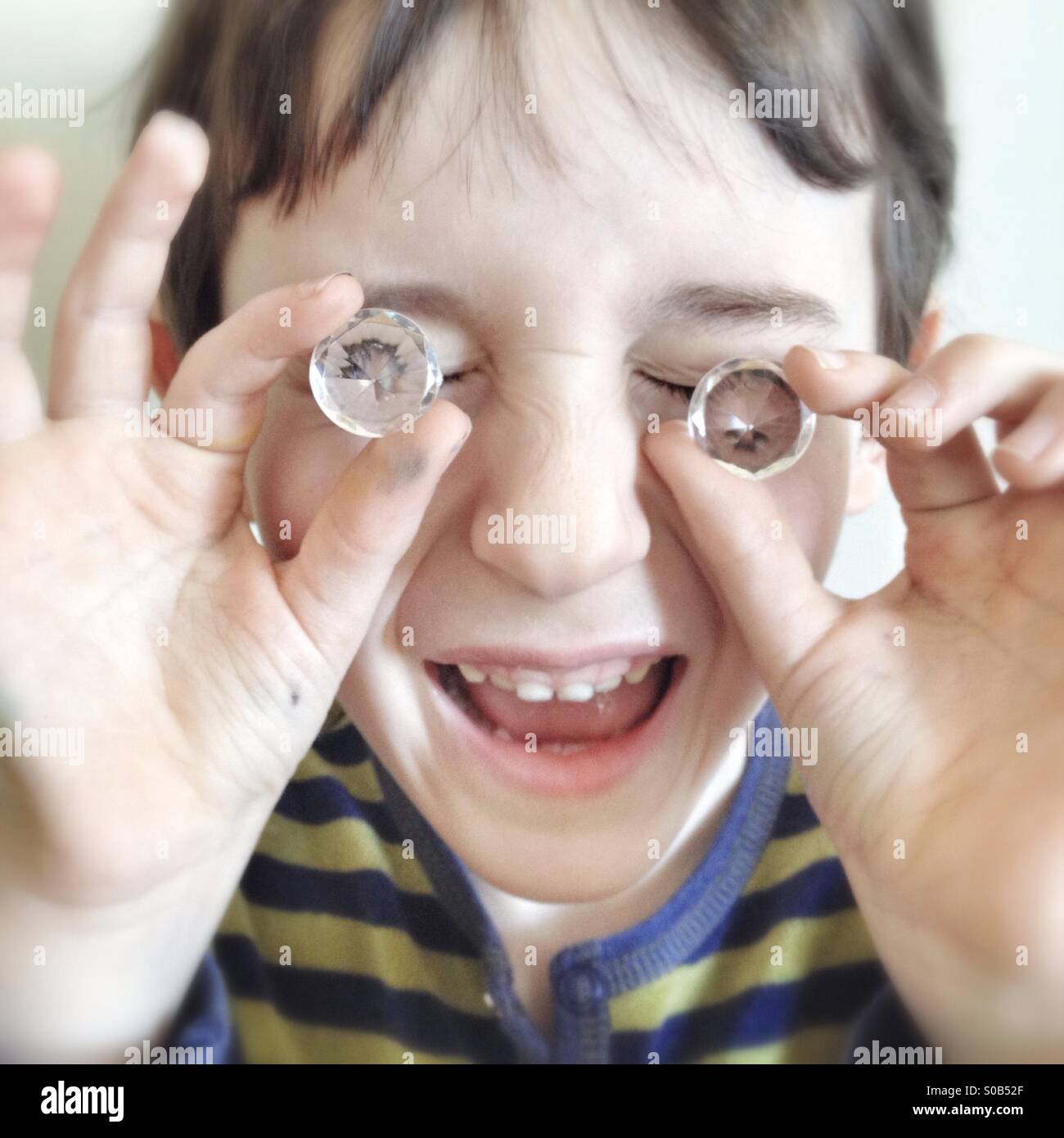 Bambino che tiene dei finti cristalli davanti agli occhi - Immagine stock catturata con smartphone