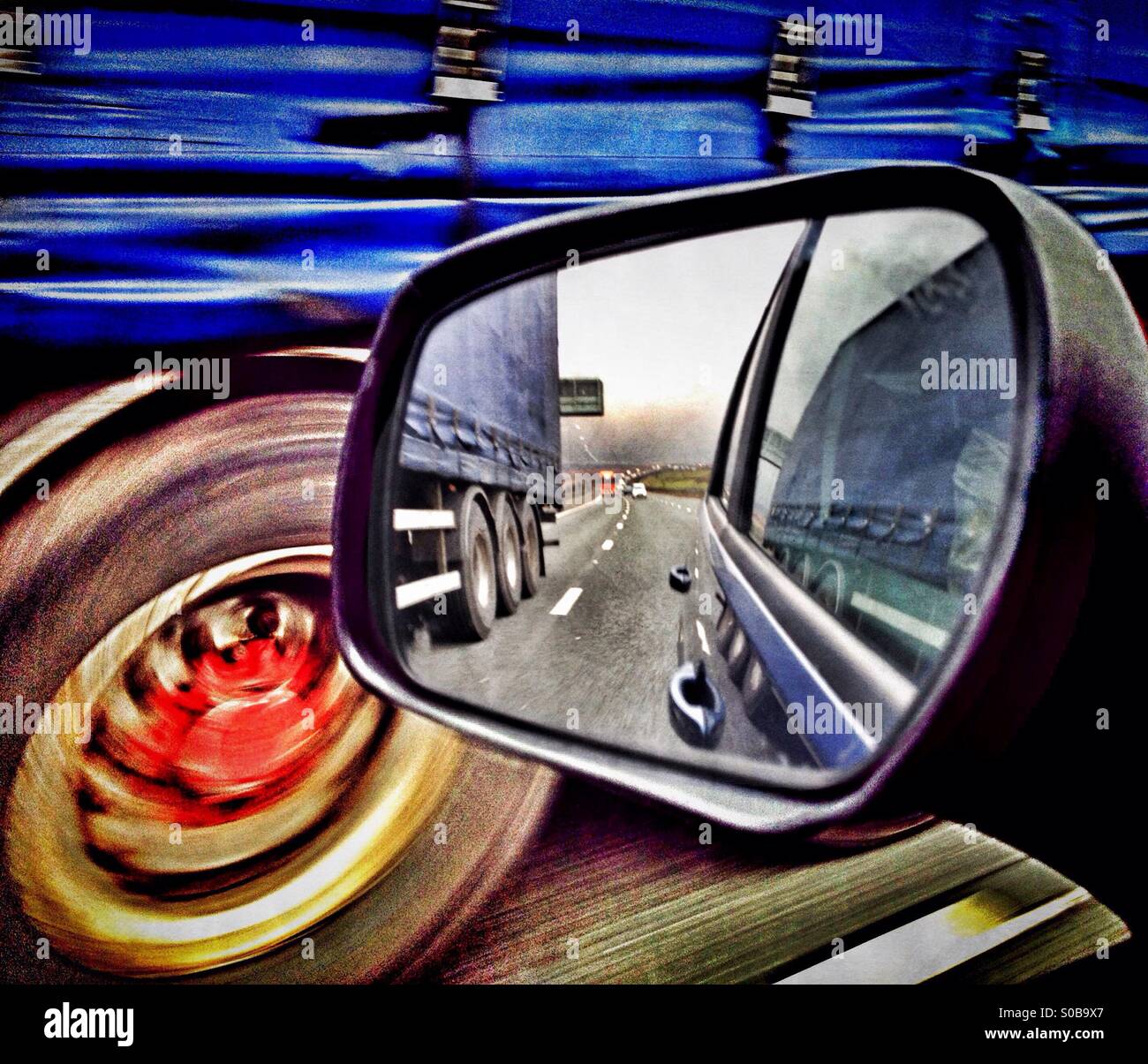 Carrello passaggio auto visto attraverso lo specchio parafango Foto Stock