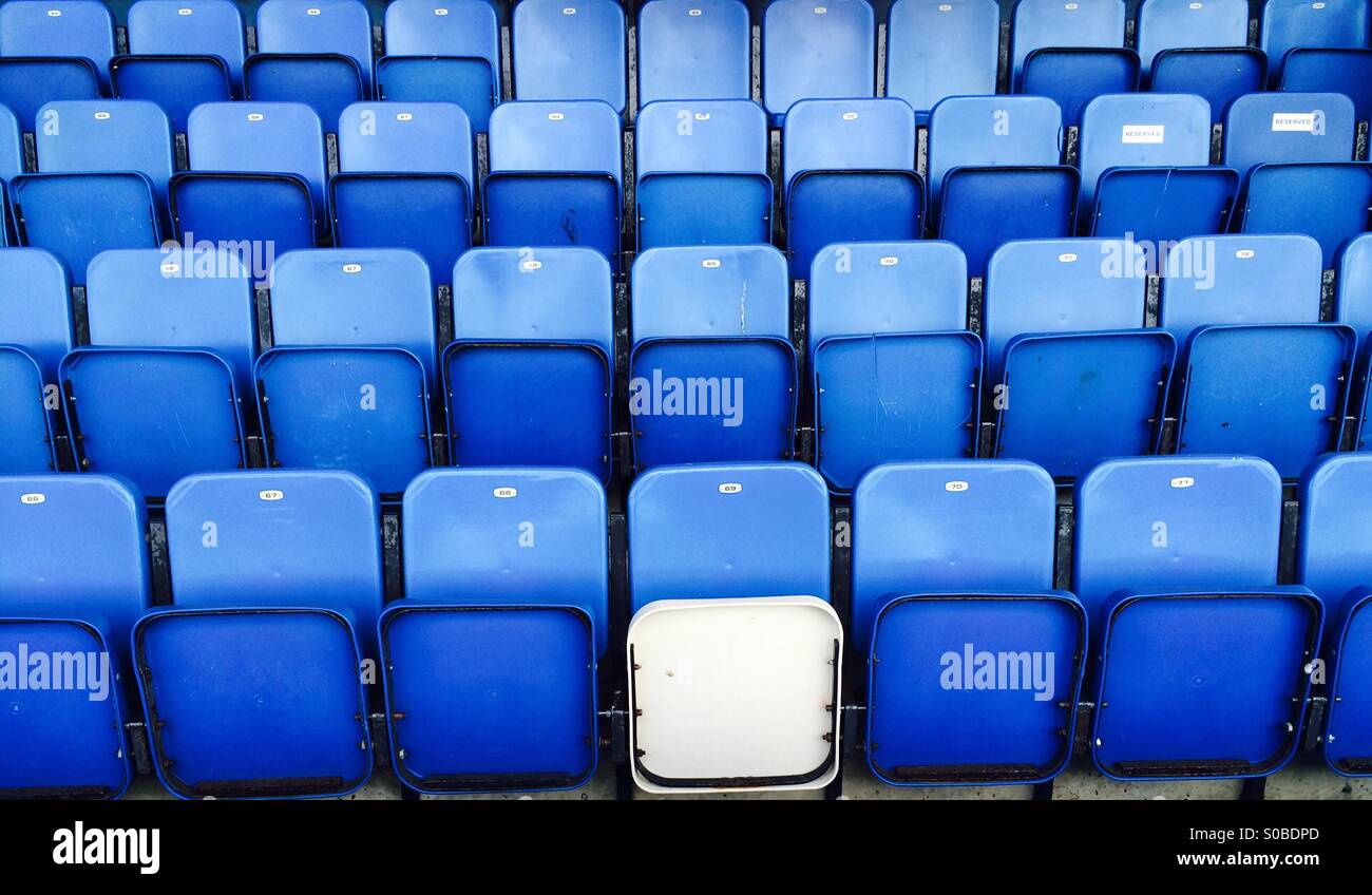 Righe di blu stadium sedi con uno bianco uno Foto Stock