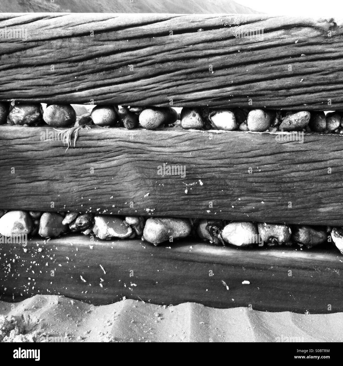 Le pietre che si incunea nel mare di difese dalla marea sulla Costa North Norfolk. Foto Stock