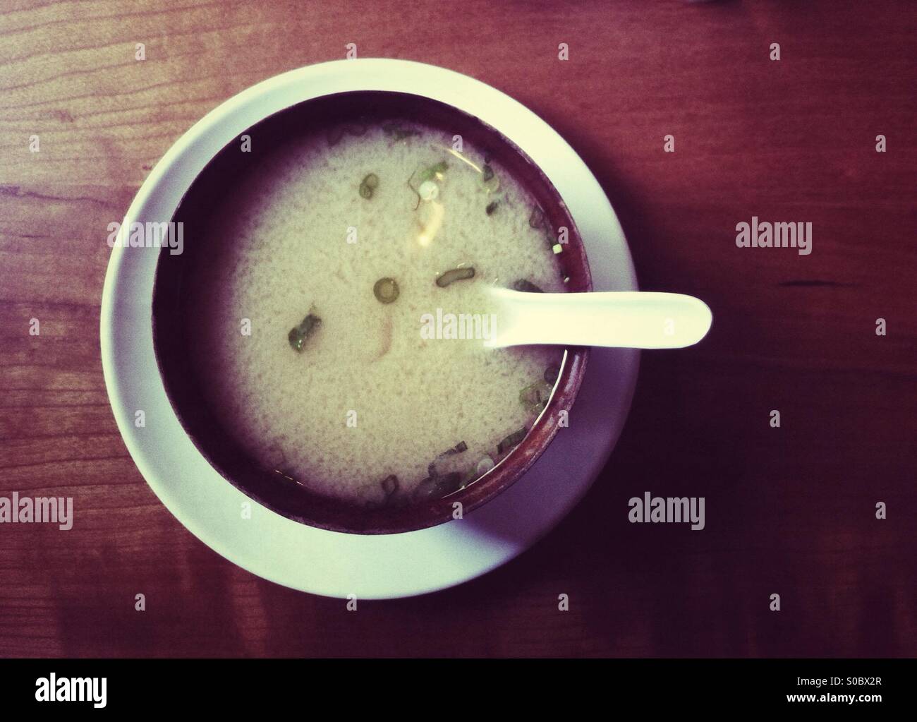 Giapponese tradizionale zuppa di miso in ciotola di legno su legno scuro tabella - Immagine stock catturata con smartphone
