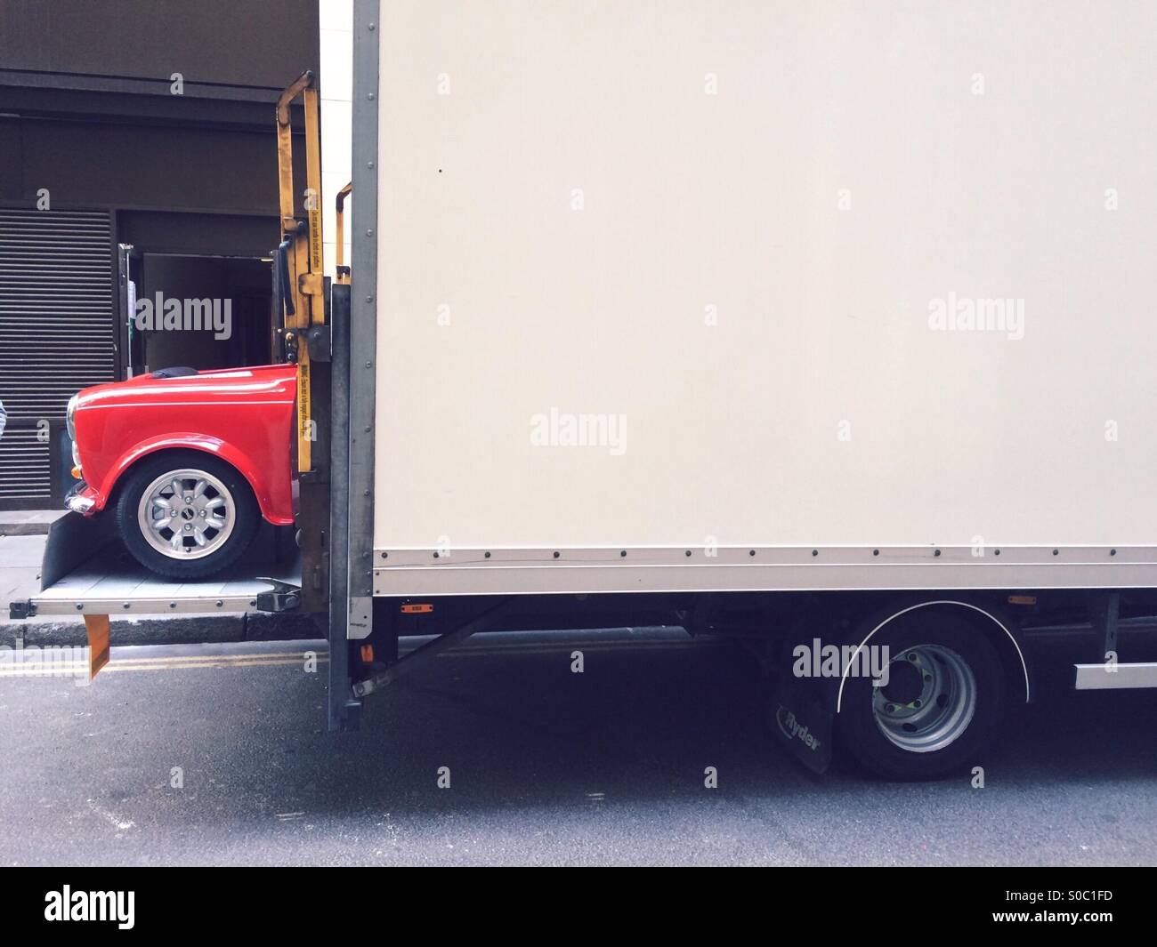 Austin Mini auto prendendo fuori della fine di un camion nel centro di Londra - Immagine stock catturata con smartphone