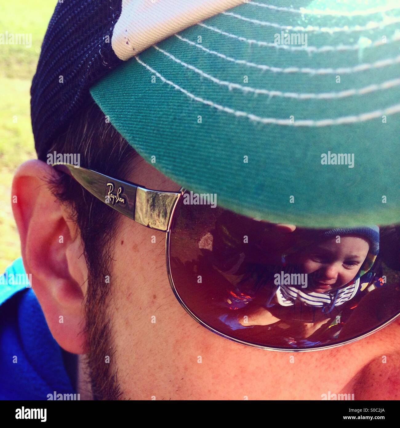 Un bambino è riflessa in Daddy's occhiali da sole Foto Stock