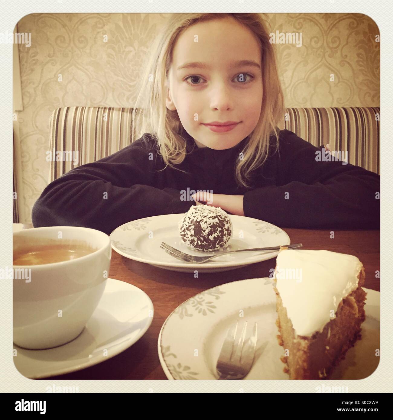 Andando fuori per un caffè e torte con un giovane figlia in un elegante caffe'. Crescono lentamente e unire il mondo degli adulti... Foto Stock
