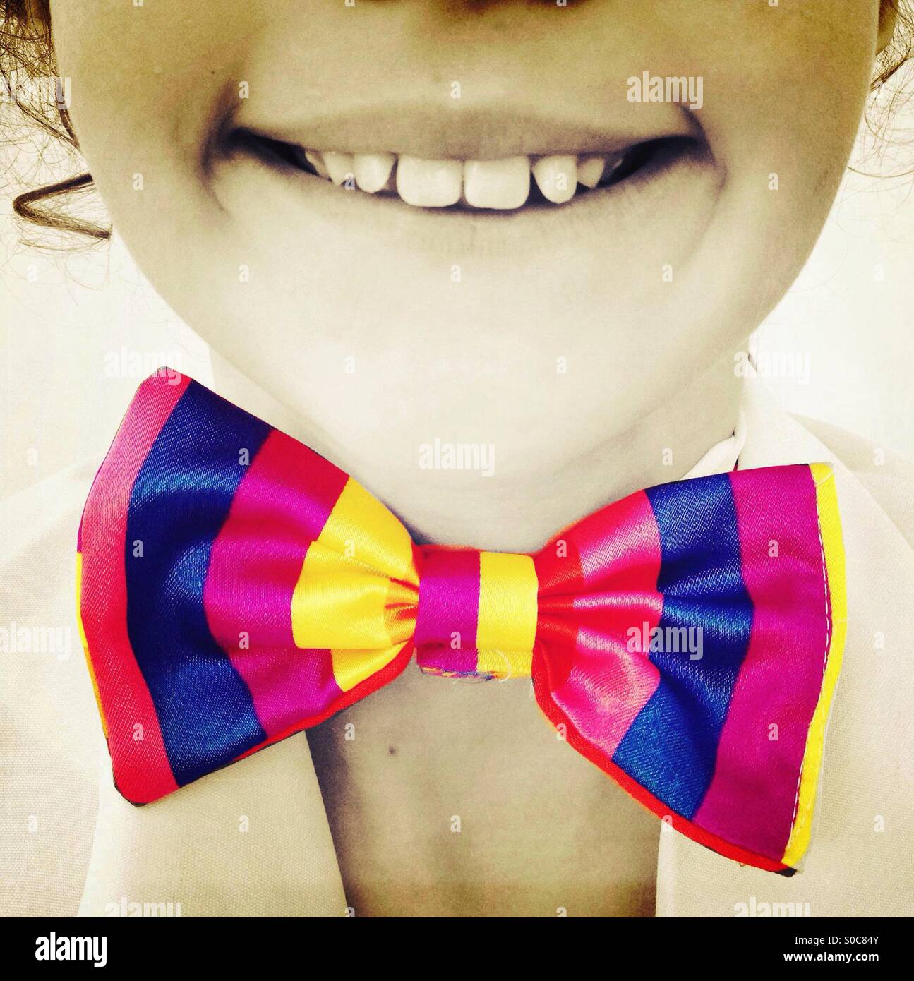 Ragazza sorridente indossando variopinti bow tie Foto Stock